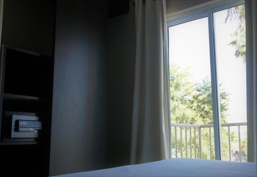 Villa Verde Inn في سان خوان: غرفة نوم بسرير ونافذة كبيرة