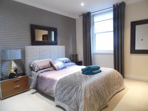 a bedroom with a bed and a mirror on the wall at WEST END -Stunning, 2 bedroom, main door flat with private parking in Glasgow