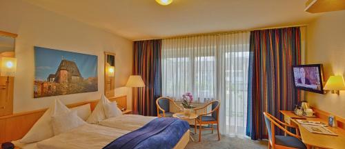 ein Hotelzimmer mit einem Bett und einem Schreibtisch in der Unterkunft Trip Inn Hotel Zum Riesen Hanau in Hanau am Main