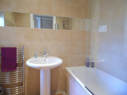 a bathroom with a sink and a bath tub at WEST END - Stunning, spacious, 3 bedroom, main door flat with private parking in Glasgow