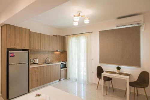 a kitchen with a refrigerator and a table with chairs at Bounatsa Studios & Apartments in Nydri