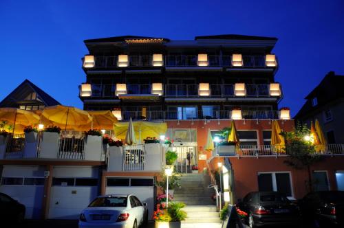 a building with cars parked in front of it at Seehotel OFF in Meersburg