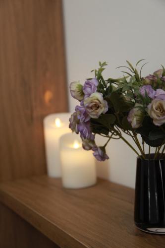 a vase with purple flowers and candles on a table at Rio in Tbilisi City