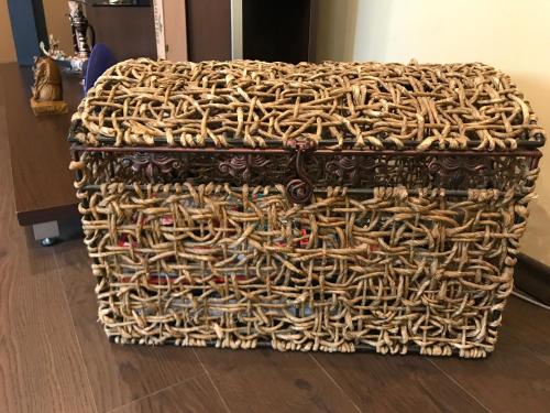 a large wicker chest sitting on a wooden floor at Chris Apart in Vulcan
