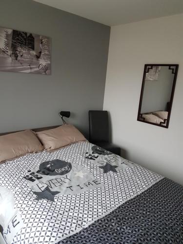 ein Schlafzimmer mit einem Bett mit einem Bild darauf in der Unterkunft maison individuelle 500 m de la mer in Agon Coutainville