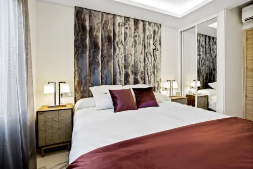 una camera da letto con un grande letto bianco con cuscini viola di Luxury Villa Marbella with nice garden, Pool and Jacuzzi BY Varenso Holidays a Marbella