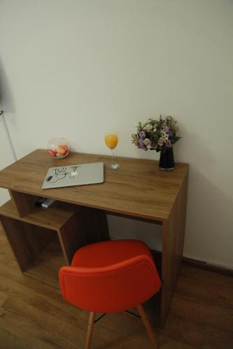a wooden desk with a red chair and a glass of wine at Rio in Tbilisi City