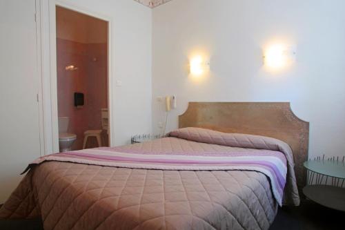 a bedroom with a large bed in a room at Hôtel restaurant LOGIS HOTELLERIE DE BALAJAN in Vic-la-Gardiole