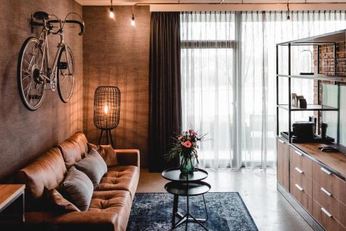 a living room with a couch and a bike on the wall at Van der Valk Hotel Melle - Osnabrück in Melle