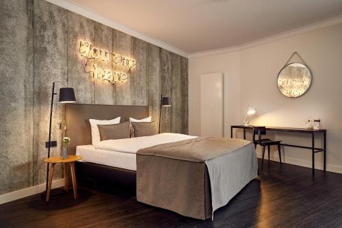 Van der Valk Hotel Melle - Osnabrück في ميله: غرفة نوم بسرير كبير وعلامة على الحائط