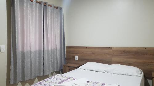 a bedroom with a bed and a window at Pousada dos Guias in Alto Paraíso de Goiás