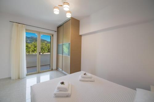 a bedroom with a bed with two towels on it at Bounatsa Studios & Apartments in Nydri