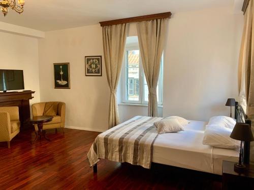 1 dormitorio con 1 cama, TV y ventana en Room 1783 Old town en Dubrovnik
