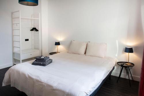 uma cama branca num quarto com duas lâmpadas em #Groentemarkt1 em Oostende