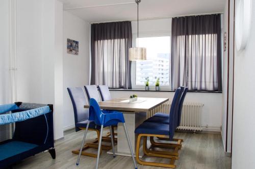 a dining room with a table and blue chairs at Ostsee Ferienpark B-2-1 Ferienwohnung Willebrand in Heiligenhafen