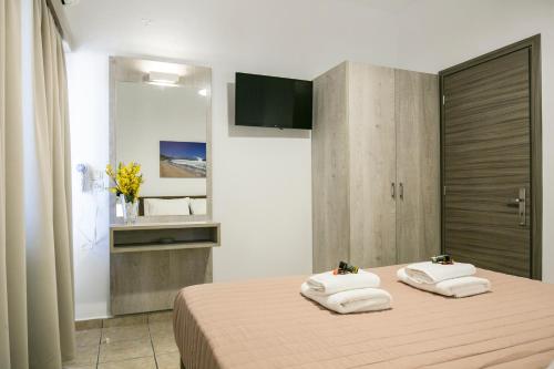 a bedroom with a bed with towels on it at Kolimbito Sea Side in Falasarna
