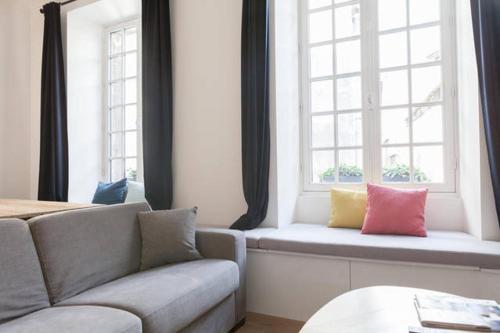 sala de estar con sofá y 2 ventanas en Chemin du muguet, en Burdeos