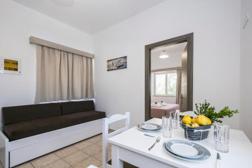 a living room with a couch and a table with a dining room at Kolimbito Sea Side in Falasarna