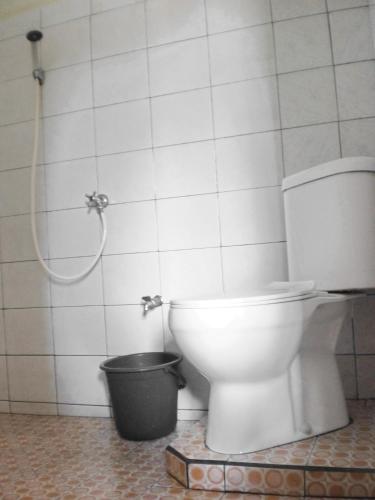 a bathroom with a toilet and a bucket at Arjuna Homestay Ubud in Ubud