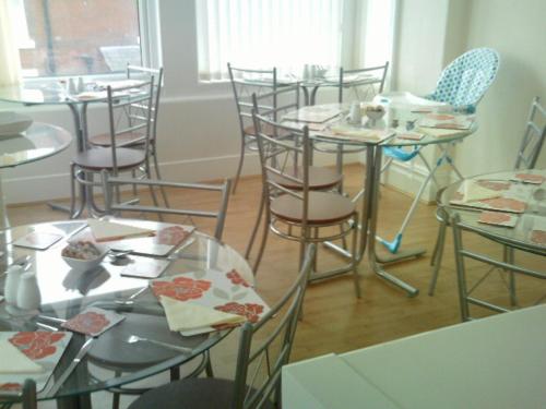 ブラックプールにあるArlingtonsの食べ物を載せたテーブルと椅子