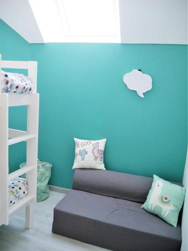 Cette chambre dispose d'un lit avec un mur bleu. dans l'établissement Casa Maya, à Saint-Aignan