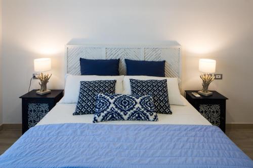 a bed room with a white bedspread and a blue comforter at Residence Mar Mediterraneo in Quartu SantʼElena