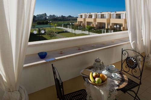a table with a bowl of fruit on it with a window at Residence Mar Mediterraneo in Quartu SantʼElena