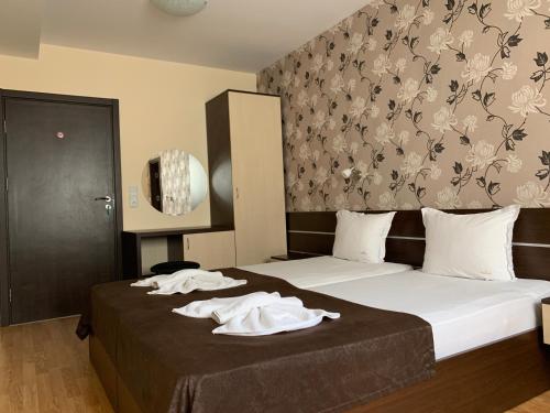 1 dormitorio con 1 cama con 2 toallas en Family Hotel Piter, en Golden Sands