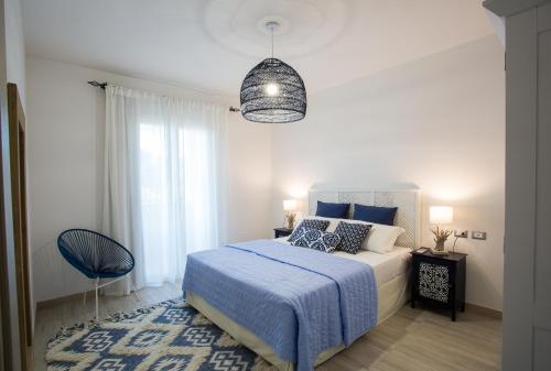 een slaapkamer met een bed met een blauwe deken bij Residence Mar Mediterraneo in Quartu SantʼElena