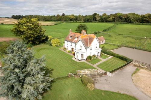 uma vista aérea de uma grande casa branca num campo em Lower Bryanston Farm em Blandford Forum