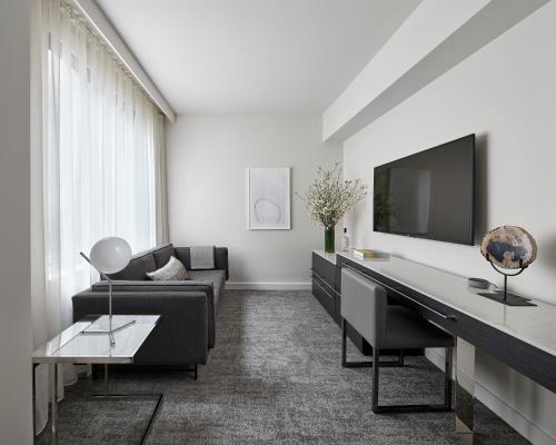 a living room with a couch and a desk and a tv at Smyth Tribeca in New York