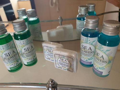 a counter with several bottles of soap and a mirror at Family Hotel Piter in Golden Sands
