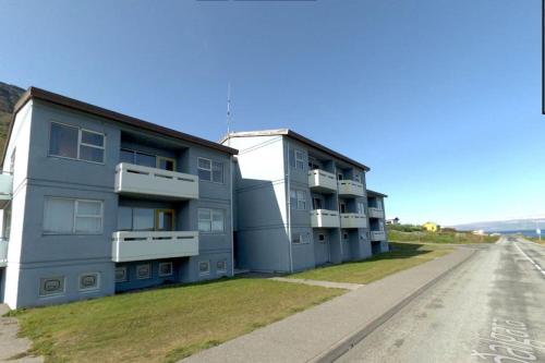 Súðavík apartment في Súðavík: مبنى أزرق بشرفات على جانب الطريق