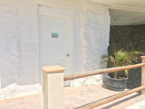 a porch with a white door and a potted plant at Villa Paraíso in La Ventana