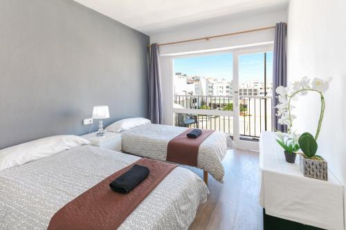 a hotel room with two beds and a balcony at PARADISE IBIZA ( Apto. Turístico 1 llave ) in San Antonio