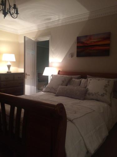 a bedroom with a large bed with two lamps at Hillcrest farmhouse Bed & Breakfast in Boyhollagh
