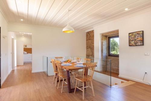 a dining room with a wooden table and chairs at Mariana's HeartMade House in Caldelas