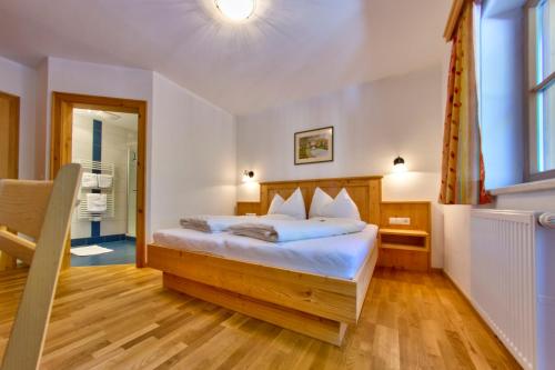 a bedroom with a bed with white sheets and a window at Sonnalm in Altenmarkt im Pongau