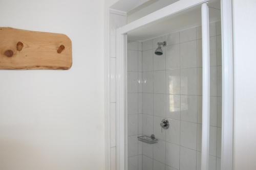 bagno con doccia e piastrelle bianche di Agri Scinghiöra a Brontallo