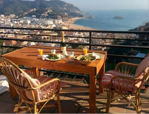 a wooden table with two plates of food on a balcony at PARADIS TOSSA in Tossa de Mar