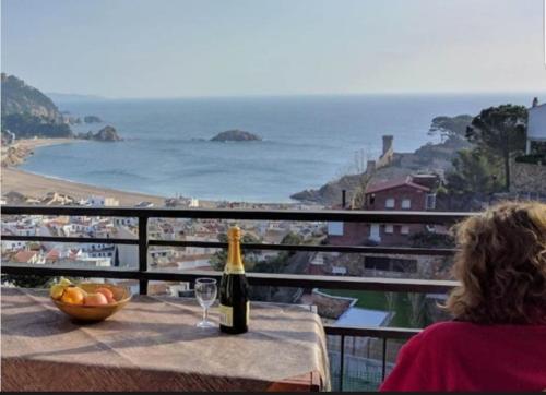 a woman sitting at a table with a bottle of wine at PARADIS TOSSA in Tossa de Mar