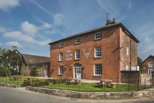 a brick building with picnic tables in front of it at The Clive Arms in Ludlow