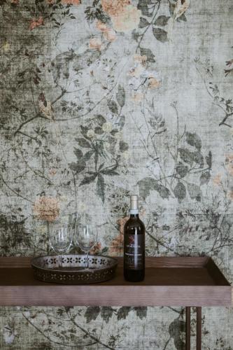a bottle of alcohol sitting on a shelf next to glasses at Ca Muretta Relais in Bardolino