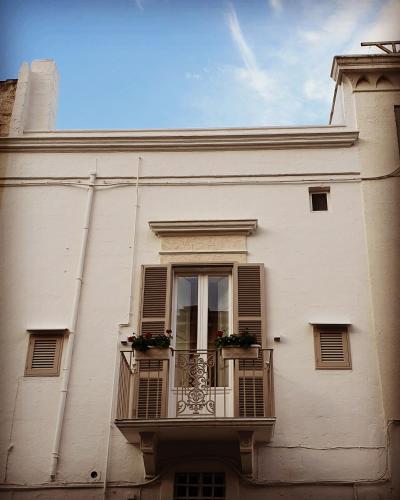 a white building with a balcony with flowers on it at Christian's Suites & Spa in Fasano