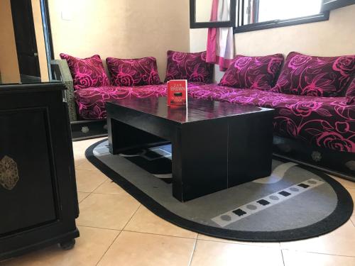 a black coffee table in a living room with a couch at Ali Appartement in Essaouira
