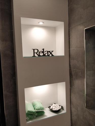 a bathroom with green pillows and a sign on the wall at Modern Luxe Marsaskala Maisonette in Marsaskala