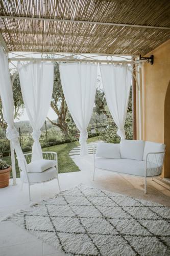 a living room with a white couch and chairs at Ca Muretta Relais in Bardolino