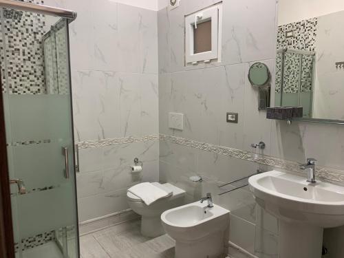 uma casa de banho branca com um WC e um lavatório em L'oasi di Ambra em Ardea