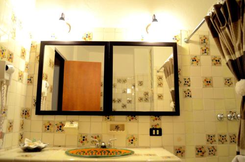 a bathroom with a mirror and a sink at Posada de la Aldea in San Miguel de Allende