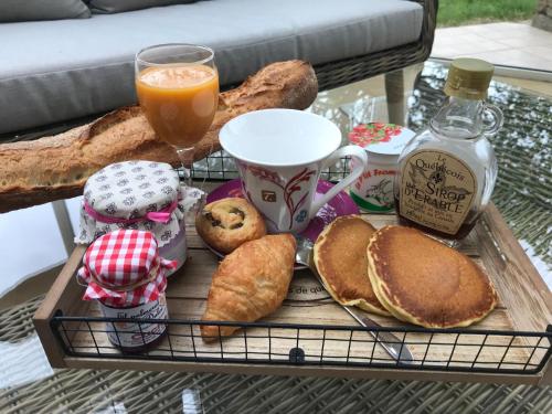 bandeja de desayuno con pan y zumo de naranja en La Petite Chaunière, en Saint-Fulgent
